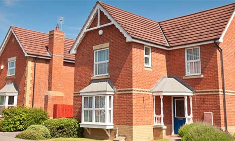 detached red brick house with blue door and white windows